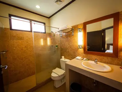 a bathroom with a toilet and a sink and a shower at Yulia Beach Inn Kuta in Kuta