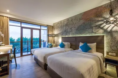 a hotel room with two beds and a desk and a desk at Wyndham Garden Kuta Beach Bali in Kuta