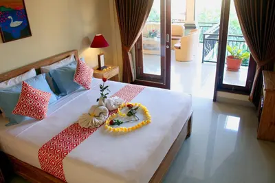 a bedroom with a bed with flowers on it at CR Tris Rooms Seminyak in Seminyak
