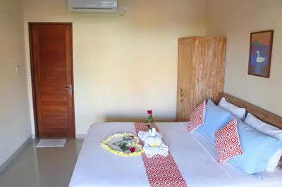 a bedroom with a bed with a flower arrangement on it at CR Tris Rooms Seminyak in Seminyak