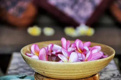 a bowl filled with pink and white flowers on a table at The Sanyas Suite Bali in Seminyak