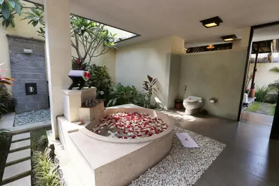 a bathroom with a large bath tub with a toilet at The Sanyas Suite Bali in Seminyak
