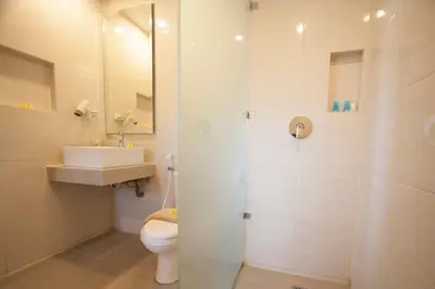 a bathroom with a toilet and a sink and a shower at Seminyak Paradiso Hotel in Seminyak