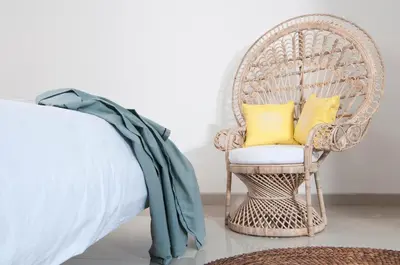 a wicker chair with two yellow pillows in a bedroom at 3BR Villa Erja - Minggu Villas - Special Stay Bonus in Kerobokan