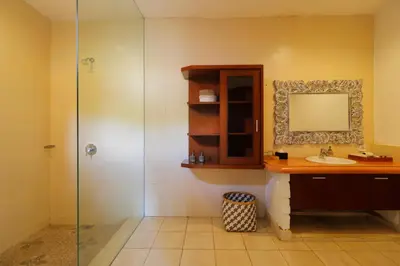 a bathroom with a sink and a mirror and a shower at Singgah Villas Seminyak in Seminyak