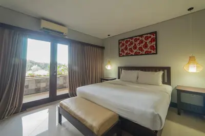 a bedroom with a large bed and a window at Nirmala Hotel Jimbaran in Jimbaran