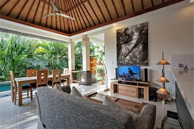 a living room with a couch and a table and a tv at Rumah Indah Villa in Seminyak