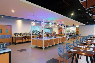 a restaurant with tables and chairs and a buffet at Kuta Beach Club Hotel in Kuta