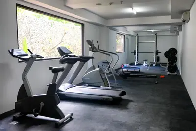 a gym with three exercise bikes and a window at Kuta Beach Club Hotel in Kuta
