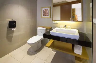 a bathroom with a white toilet and a sink at Kuta Beach Club Hotel in Kuta