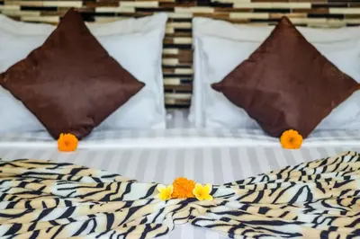 a bed with two pillows and flowers on it at Villa Safari in Seminyak