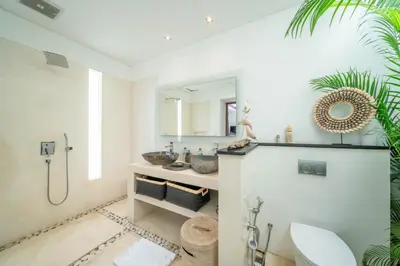 a bathroom with a shower and a toilet and a sink at Villa Tira - Elegant 3BR in Central Seminyak in Seminyak