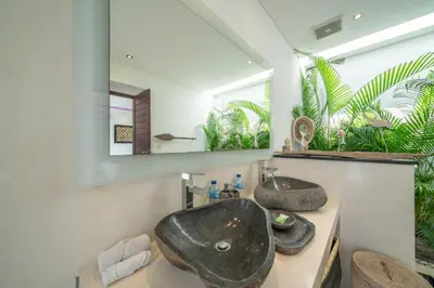a bathroom with a sink and a mirror at Villa Tira - Elegant 3BR in Central Seminyak in Seminyak