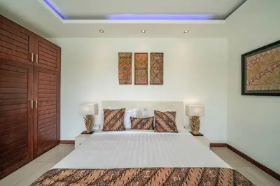 a bedroom with a large white bed with two lamps at Villa Tira - Elegant 3BR in Central Seminyak in Seminyak