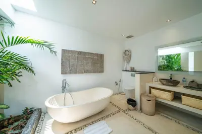 a bathroom with a white tub and a sink at Villa Tira - Elegant 3BR in Central Seminyak in Seminyak