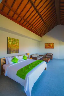 a bedroom with a large white bed with green sheets at Sun Shoot Villas Seminyak in Seminyak