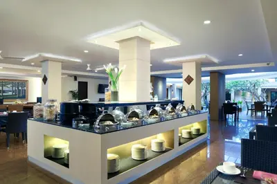 a buffet in a restaurant with dishes on display at Hotel Santika Kuta in Kuta