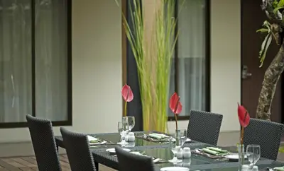 a table with chairs and wine glasses on it at Hotel Santika Kuta in Kuta