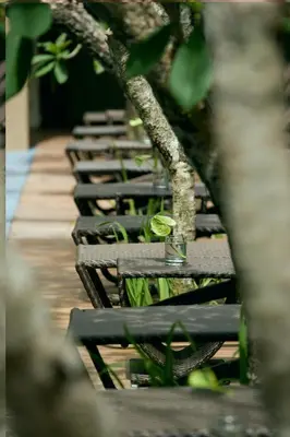 a row of benches sitting on a wooden deck at Hotel Santika Kuta in Kuta