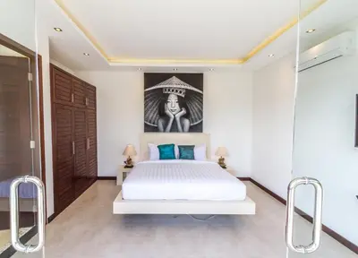 a bedroom with a white bed with blue pillows at Villa Nala - Amazing 3-Bedroom in Seminyak in Seminyak