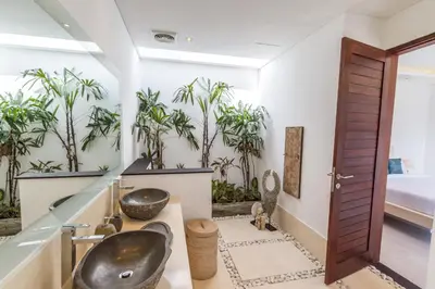 a bathroom with two sinks and palm trees at Villa Nala - Amazing 3-Bedroom in Seminyak in Seminyak