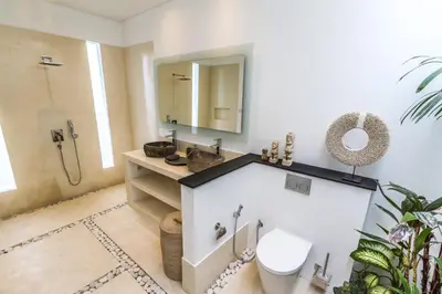 a bathroom with a sink and a toilet and a mirror at Villa Saha - Elegant 3-Bedroom in Seminyak in Seminyak