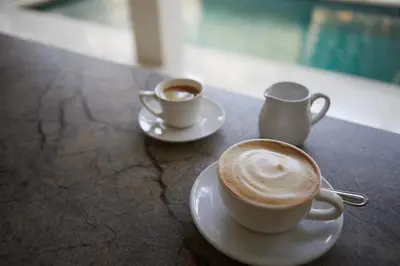 two cups of coffee sitting on a table at Ahimsa Beach in Jimbaran