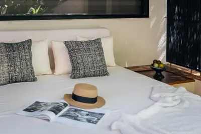 a hat sitting on top of a bed with a book at Sadara Resort in Nusa Dua