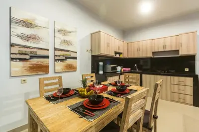 a kitchen with a wooden table and chairs in a room at Castro Villa in Seminyak