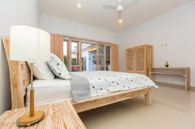 a bedroom with a bed and a lamp on a table at Castro Villa in Seminyak