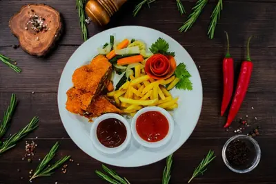 a plate of food with meat and vegetables on a table at Nirmala Hotel & Convention Centre in Denpasar