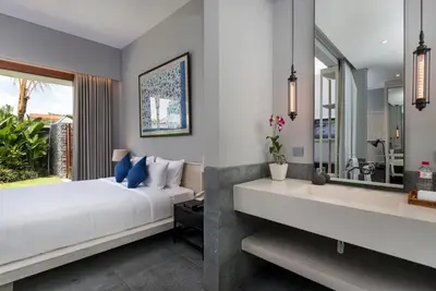 a bedroom with a bed and a sink and a mirror at Amarin Seminyak in Seminyak