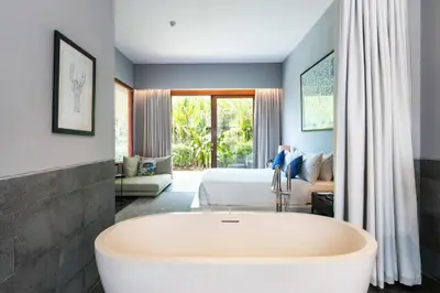 a bathroom with a tub in front of a bedroom at Amarin Seminyak in Seminyak