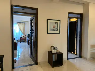 a hallway with two open doors and a living room at Nirwana Suites in Denpasar
