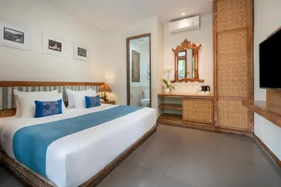 a bedroom with a large bed and a television at Pondok Sari Kuta in Kuta