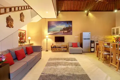 a living room with a couch and a kitchen at Concetta Villa Seminyak Beachside By Bali Asia Villa in Seminyak
