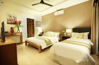 a bedroom with two beds and a flat screen tv at Villa The Hotman Paris II Seminyak in Seminyak