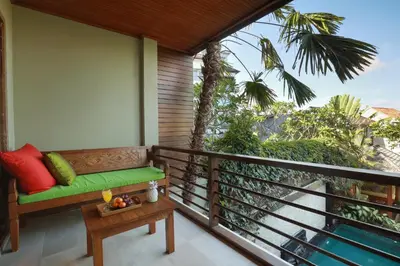 a porch with a bench on a balcony at Villa The Hotman Paris II Seminyak in Seminyak