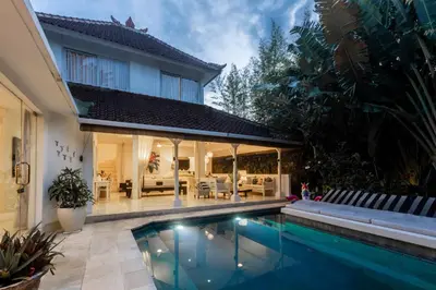 a house with a swimming pool in front of a house at Esha Villa Drupadi Seminyak in Seminyak