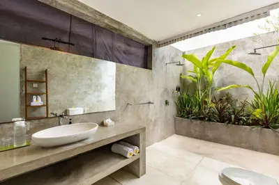 a bathroom with a sink and a mirror and plants at Esha Villa Drupadi Seminyak in Seminyak