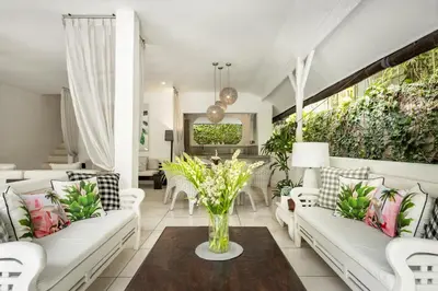 a living room with white couches and a table at Esha Villa Drupadi Seminyak in Seminyak
