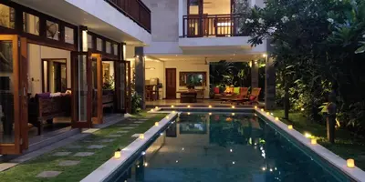 a pool in the backyard of a house at night at Villa Khaleesi in Seminyak