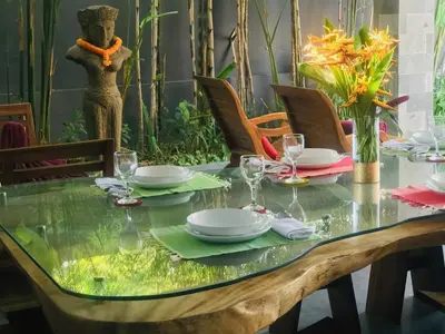 a table with plates and glasses on top of it at Villa Khaleesi in Seminyak