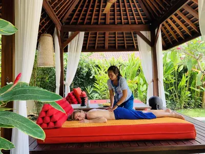 a woman is laying on a bed in a room at Kamehameha Luxury Villa in Seminyak