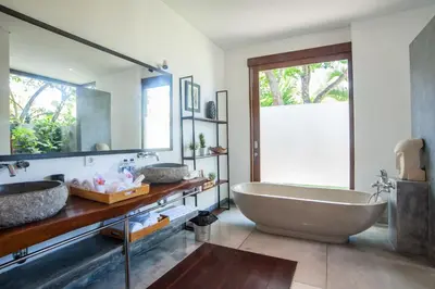 a bathroom with a large tub and two sinks at Kamehameha Luxury Villa in Seminyak