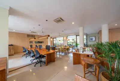 a dining room with wooden tables and chairs at Sara Residence by Nakula in Legian