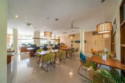 a dining room with tables and chairs in a building at Sara Residence by Nakula in Legian