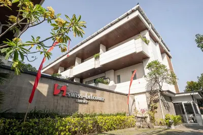a building with a sign on the side of it at Swiss-Belcourt Sunset in Seminyak