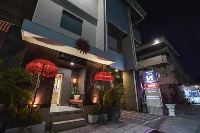 a building with red umbrellas outside of it at night at Swiss-Belcourt Sunset in Seminyak