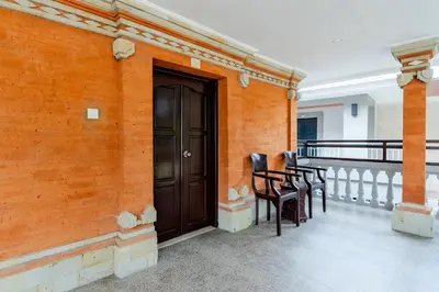 a balcony with chairs and a door on a building at Dewi Sri Hotel in Legian